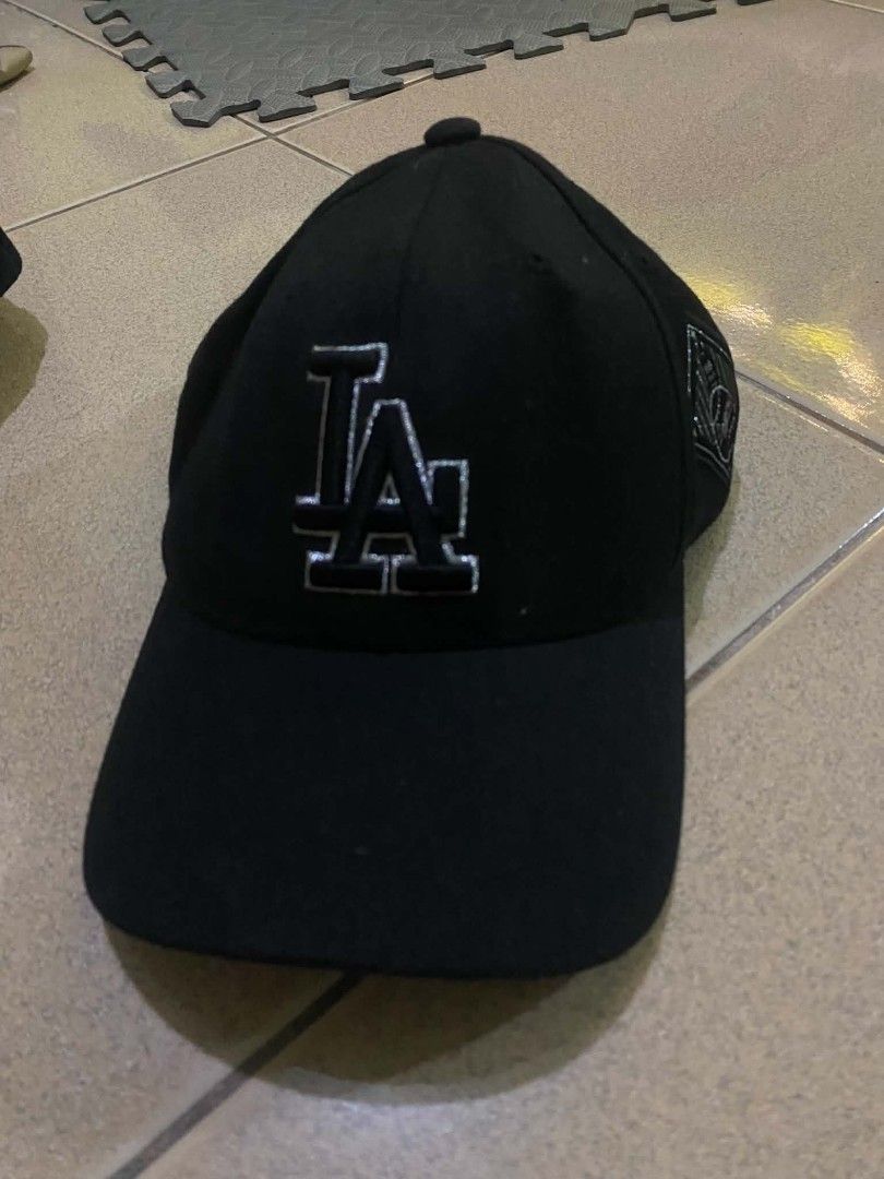 MLB Los Angeles Dodgers Black Baseball Cap (Category: Caps & Hats) located in Quezon City. Submitted by elihur.tuazon (Listing ID 1471291420, Image 1). Description: - Authentic Official MLB Merchandise - Classic black color with embroidered LA Dodgers front logo - Unique Dodgers text printed underneath the brim - Stylish side patch with baseball graphics - Adjustable strap back with metallic branding buckle - Perfect for daily casual wear or game
