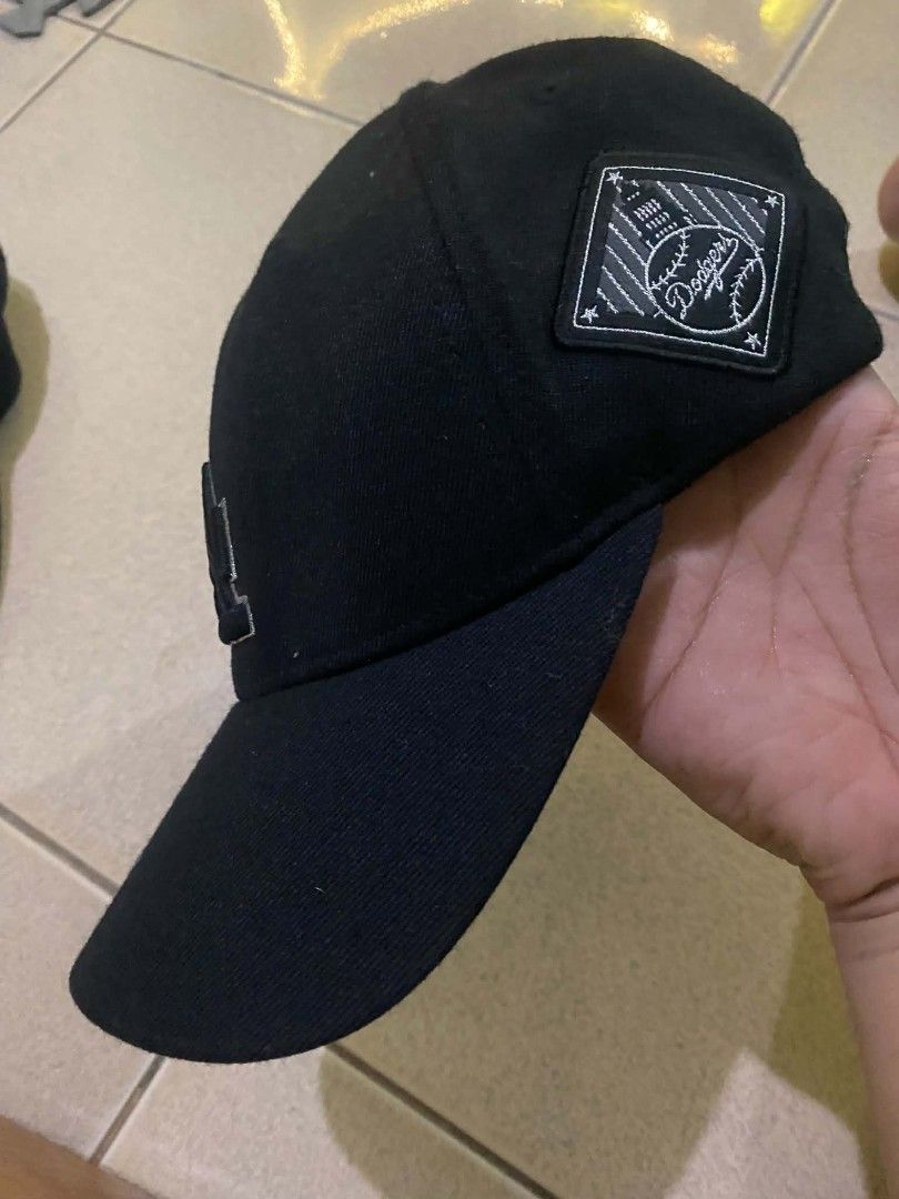 MLB Los Angeles Dodgers Black Baseball Cap (Category: Caps & Hats) located in Quezon City. Submitted by elihur.tuazon (Listing ID 1471291420, Image 2). Description: - Authentic Official MLB Merchandise - Classic black color with embroidered LA Dodgers front logo - Unique Dodgers text printed underneath the brim - Stylish side patch with baseball graphics - Adjustable strap back with metallic branding buckle - Perfect for daily casual wear or game