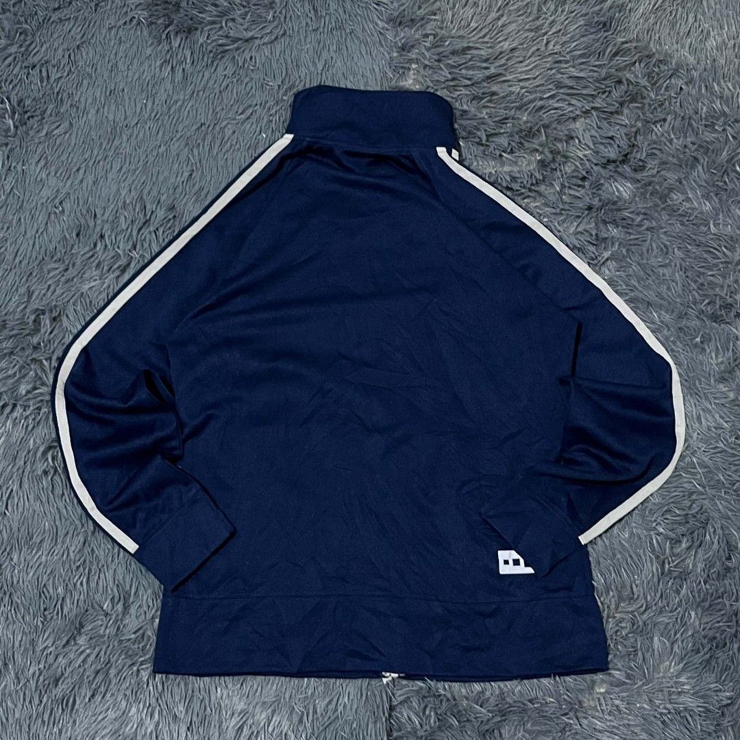 Navy Blue Track Jacket With White Stripes (Category: Coats, Jackets and Outerwear) located in Batangas. Submitted by jaylord_g (Listing ID 1471124163, Image 2). Description: - Color: Dark navy blue with contrasting white stripes and front piping - Fit & Style: Stand-up collar, full zip closure with silver pull, long sleeves with ribbed cuffs - Details: Small white graphic on lower back hem, interior red fabric detail with Japanese text tags - Mat