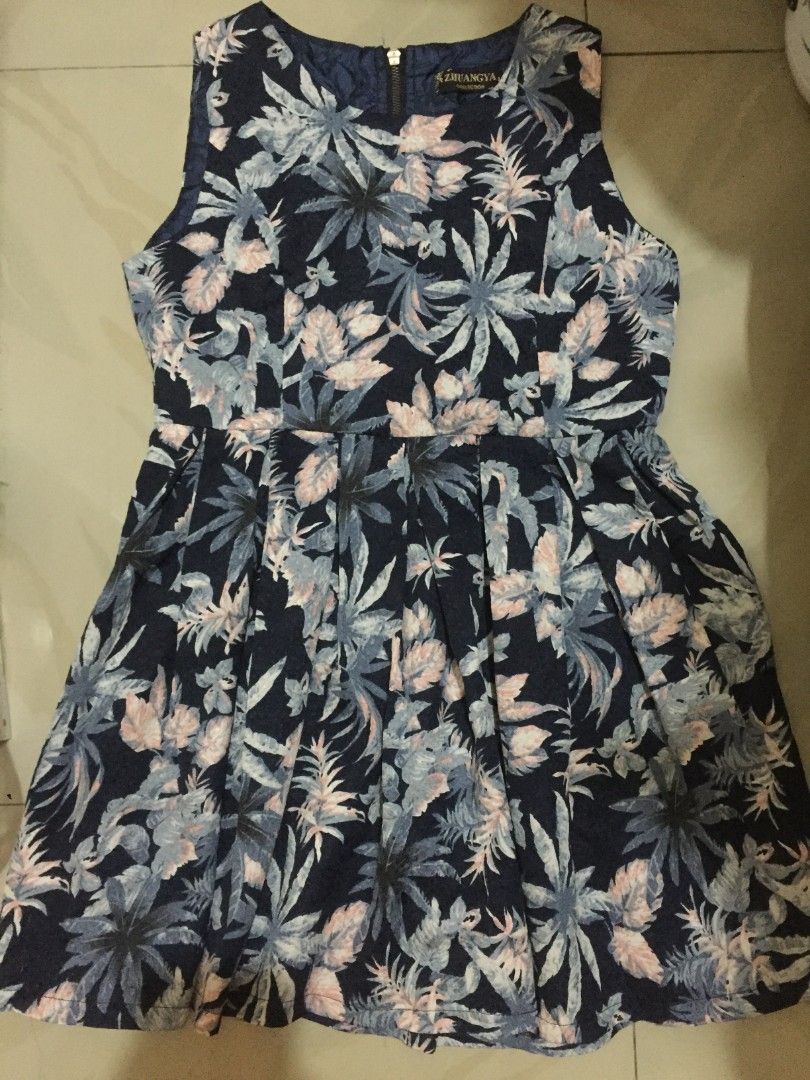 Navy Blue Tropical Leaf Print Dress (Category: Dresses) located in Marikina City. Submitted by sunflora.thrift (Listing ID 1471280350, Image 1). Description: - Brand/Label: Zhuangya Collection - Design: Navy blue with vibrant tropical leaf and floral print - Cut: Sleeveless, fitted bodice, and chic flared pleated skirt - Closure: Full-length metal zipper down the back - Material: Lightweight, breathable fabric ideal for warm weather and casual da
