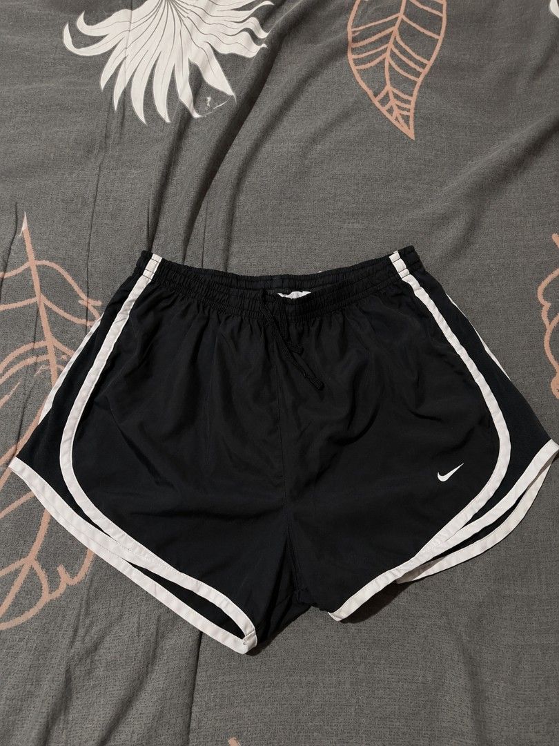 Nike Black White Trim Running Shorts (Category: Shorts) located in Urdaneta. Submitted by goldeneagle-e662 (Listing ID 1471196999, Image 1). Description: - Color: Classic Black with White contrast piping - Fit: Elastic waistband with adjustable drawstring for a secure fit - Branding: Iconic white Nike Swoosh printed on the lower left leg - Material: Lightweight, breathable fabric ideal for intense workouts or everyday athleisure - Condition: Bran