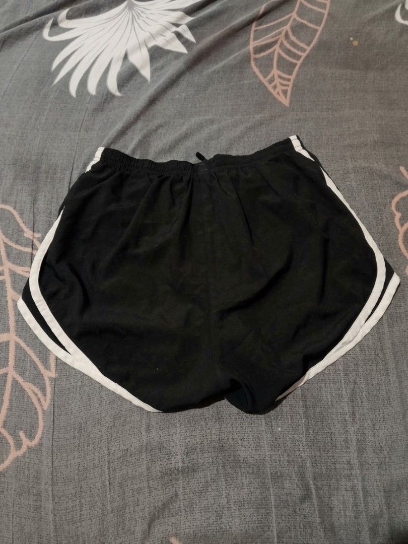 Nike Black White Trim Running Shorts (Category: Shorts) located in Urdaneta. Submitted by goldeneagle-e662 (Listing ID 1471196999, Image 2). Description: - Color: Classic Black with White contrast piping - Fit: Elastic waistband with adjustable drawstring for a secure fit - Branding: Iconic white Nike Swoosh printed on the lower left leg - Material: Lightweight, breathable fabric ideal for intense workouts or everyday athleisure - Condition: Bran