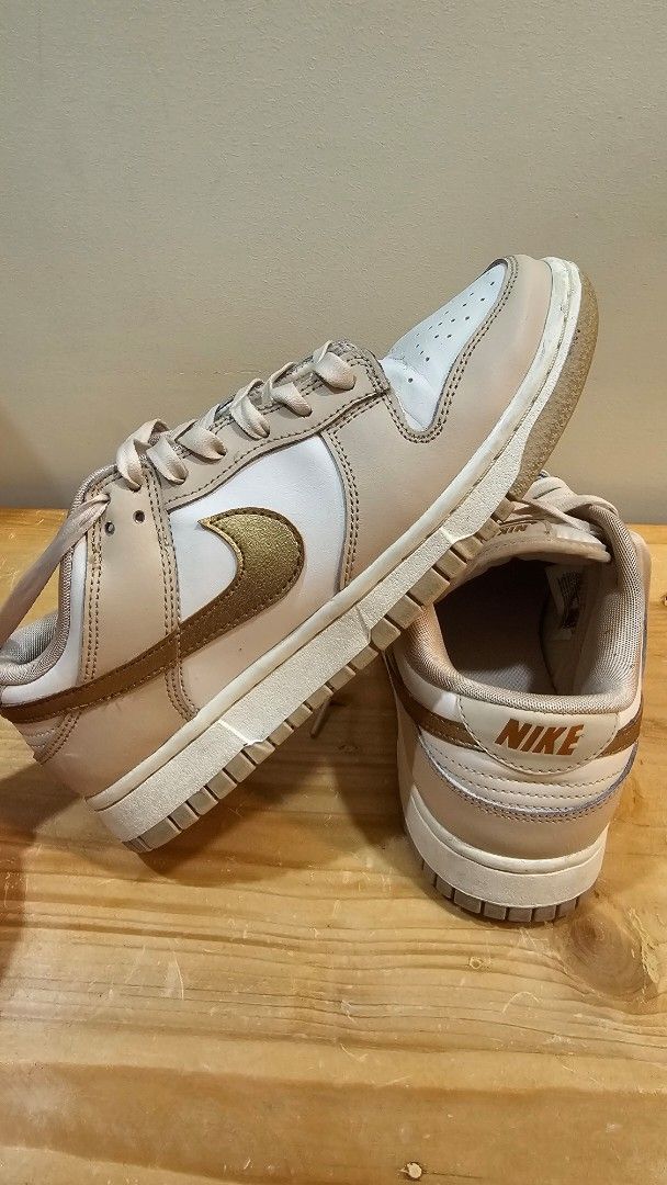Nike Dunk Low Phantom Metallic Gold (Category: Sneakers) located in Taguig. Submitted by tin50616 (Listing ID 1471226592, Image 1). Description: - Model: Nike Dunk Low - Colorway: Metallic Bronze / Gold / White / Light Beige - Style Code: DX5930-001 - Size: US 8 Women's - Details: White leather base, beige overlays, metallic gold swoosh, branded tongue and heel tabs - Condition: Good silhouette, perfect for daily wear -no box RFS: decluttering.