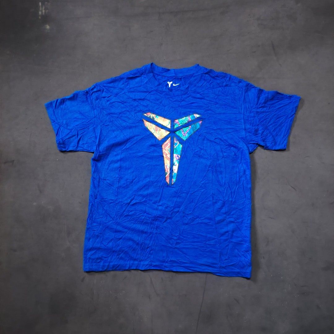 Nike Kobe Bryant (Category: Activewear) located in General Santos City (Dadiangas). Submitted by angelodemegilloceballos (Listing ID 1471135508, Image 1). Description: - Brand: Nike - Player: Kobe Bryant (colorful patterned sheath logo) - Size: L (tag verified) - Material: 100% cotton - Fit: Loose fit, short sleeves - Origin: Made in Vietnam - Condition: Clean blue fabric with clear collar tags.