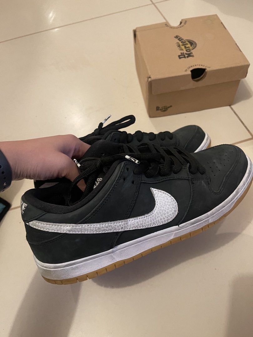 Nike SB Dunk Low Pro Black Gum Size 10.5 (Category: Sneakers) located in Quezon City. Submitted by ashleyortizzz (Listing ID 1471241527, Image 1). Description: - Model: Nike SB Dunk Low - Colorway: Black with White Swoosh and Gum Soles - Size: US 10.5 - Condition: Uppers are solid, soles are very clean with minimal wear - Extras: Custom lace tips included - Packaging: No original Nike box (Dr. Martens box in background is unrelated) - Feel free t