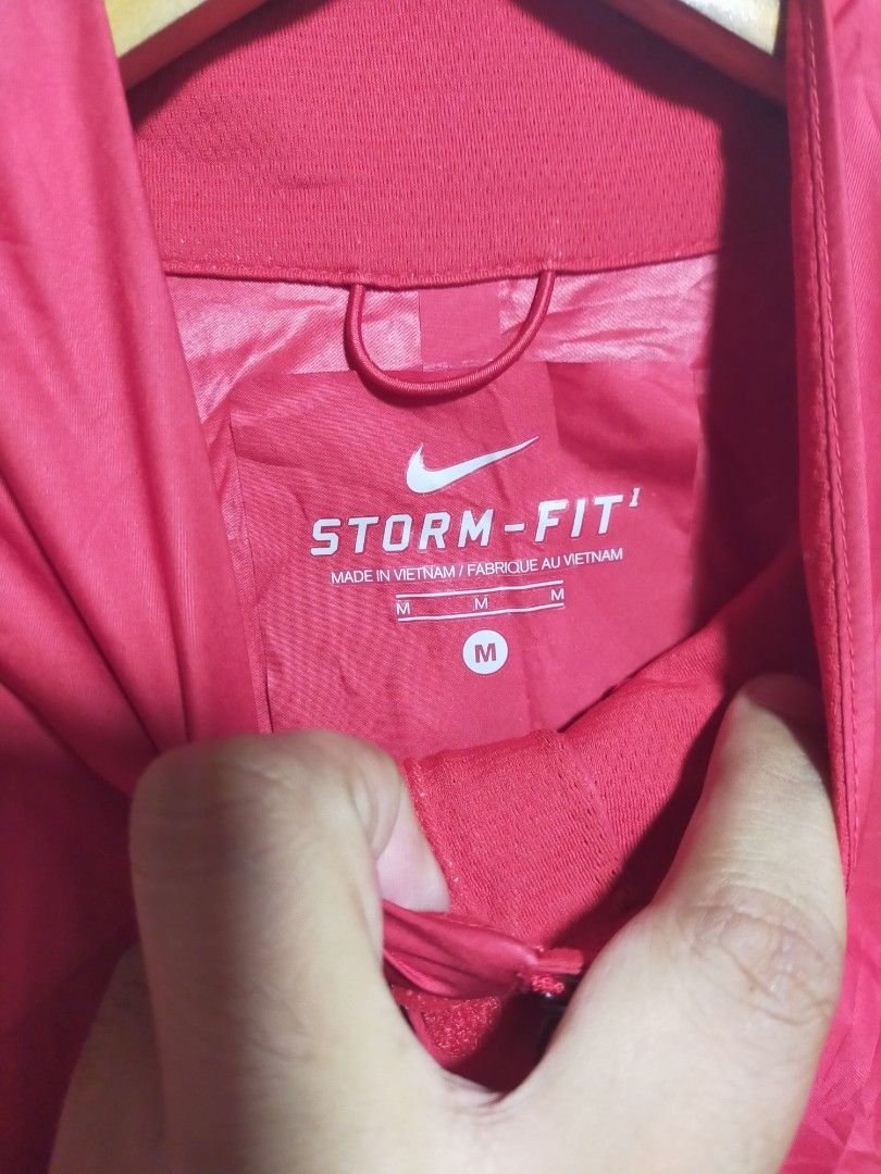 Nike Storm-Fit Red Running Jacket Size M (Category: Coats, Jackets and Outerwear) located in Valencia. Submitted by cabisaythriftshop (Listing ID 1471223279, Image 2). Description: - Brand: Nike - Model: Storm-Fit Jacket - Color: Vibrant Red - Size: Men's Medium (M) - Material: 100% polyester body, 80% polyester / 20% spandex mesh - Features: Full zip front, high collar, and reflective shoulder stripes for visibility - Performance: Excellent wind