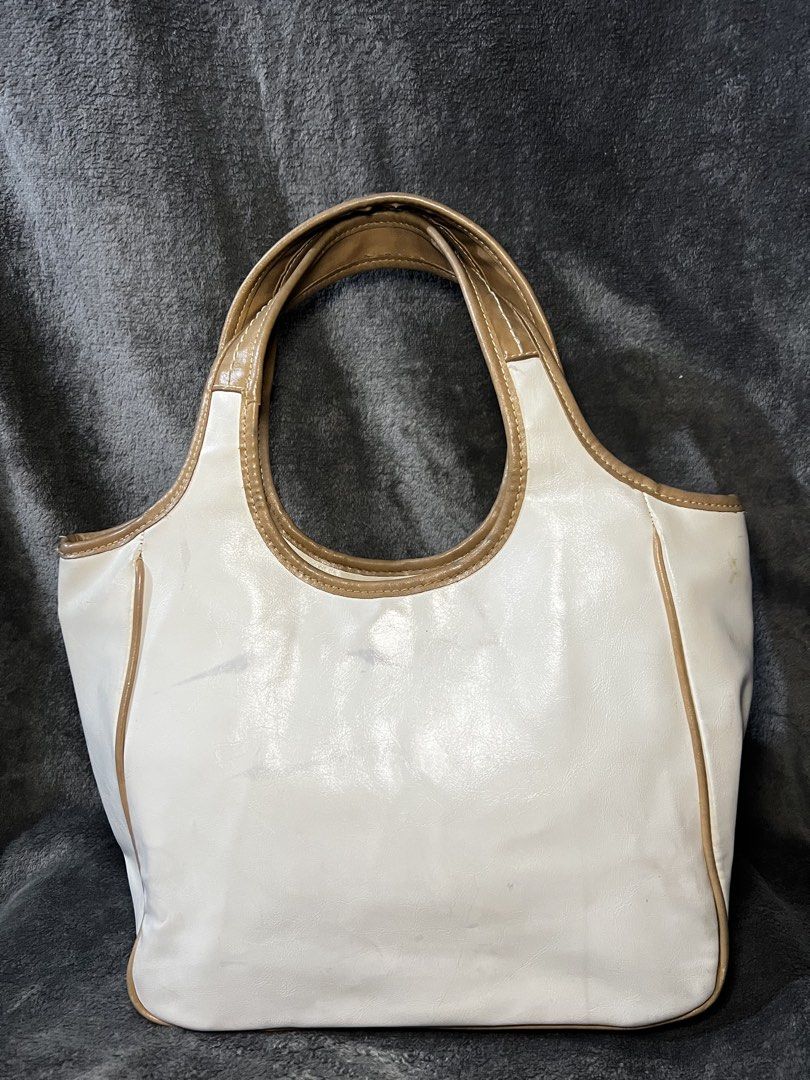Nine West Patchwork Shoulder Bag (Category: Shoulder Bags) located in Manila. Submitted by serenathriftstore (Listing ID 1471181548, Image 2). Description: Nine West shoulder bag with a patchwork design. Mix of brown, tan, and white faux leather panels. Front slip pocket featuring a silver-tone metal oval brand logo plaque. Top carry handle attached. Neutral tones match many casual daily outfits..