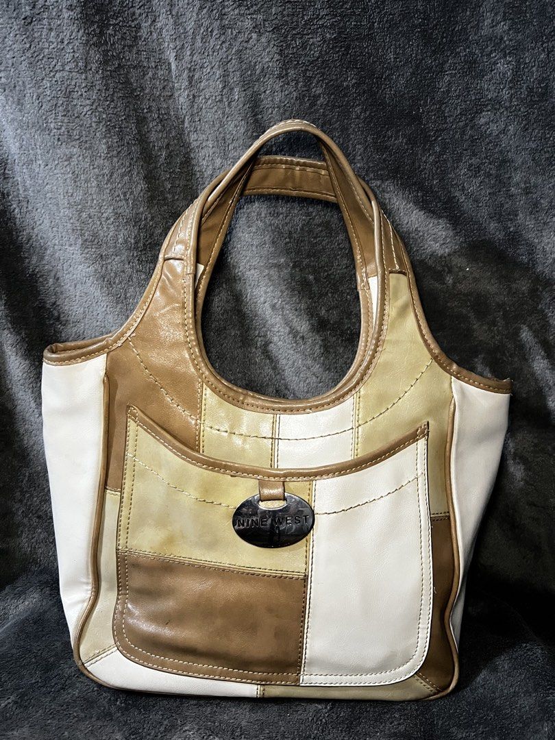 Nine West Patchwork Shoulder Bag (Category: Shoulder Bags) located in Manila. Submitted by serenathriftstore (Listing ID 1471181548, Image 1). Description: Nine West shoulder bag with a patchwork design. Mix of brown, tan, and white faux leather panels. Front slip pocket featuring a silver-tone metal oval brand logo plaque. Top carry handle attached. Neutral tones match many casual daily outfits..