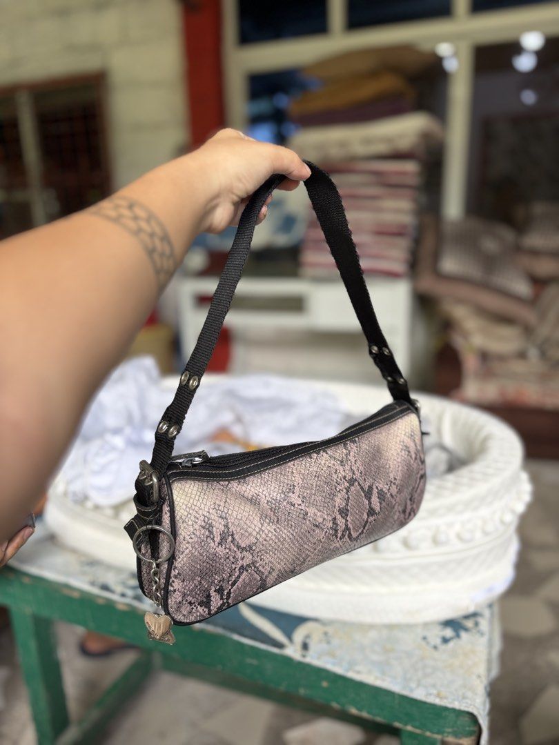 Nine West Pink Snakeskin Shoulder Bag (Category: Shoulder Bags) located in Manila. Submitted by dorilorenr48954 (Listing ID 1471223539, Image 2). Description: - Brand: Nine West - Material: Pink & black snakeskin pattern faux leather - Strap: Black nylon with silver metal eyelets and side heart charm keyring - Closure: Zipper - Interior: Beige fabric lining with logo patch and card slots - Flaw Note: Some fraying on the strap near the grommets.