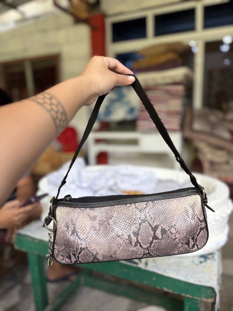 Nine West Pink Snakeskin Shoulder Bag (Category: Shoulder Bags) located in Manila. Submitted by dorilorenr48954 (Listing ID 1471223539, Image 1). Description: - Brand: Nine West - Material: Pink & black snakeskin pattern faux leather - Strap: Black nylon with silver metal eyelets and side heart charm keyring - Closure: Zipper - Interior: Beige fabric lining with logo patch and card slots - Flaw Note: Some fraying on the strap near the grommets.