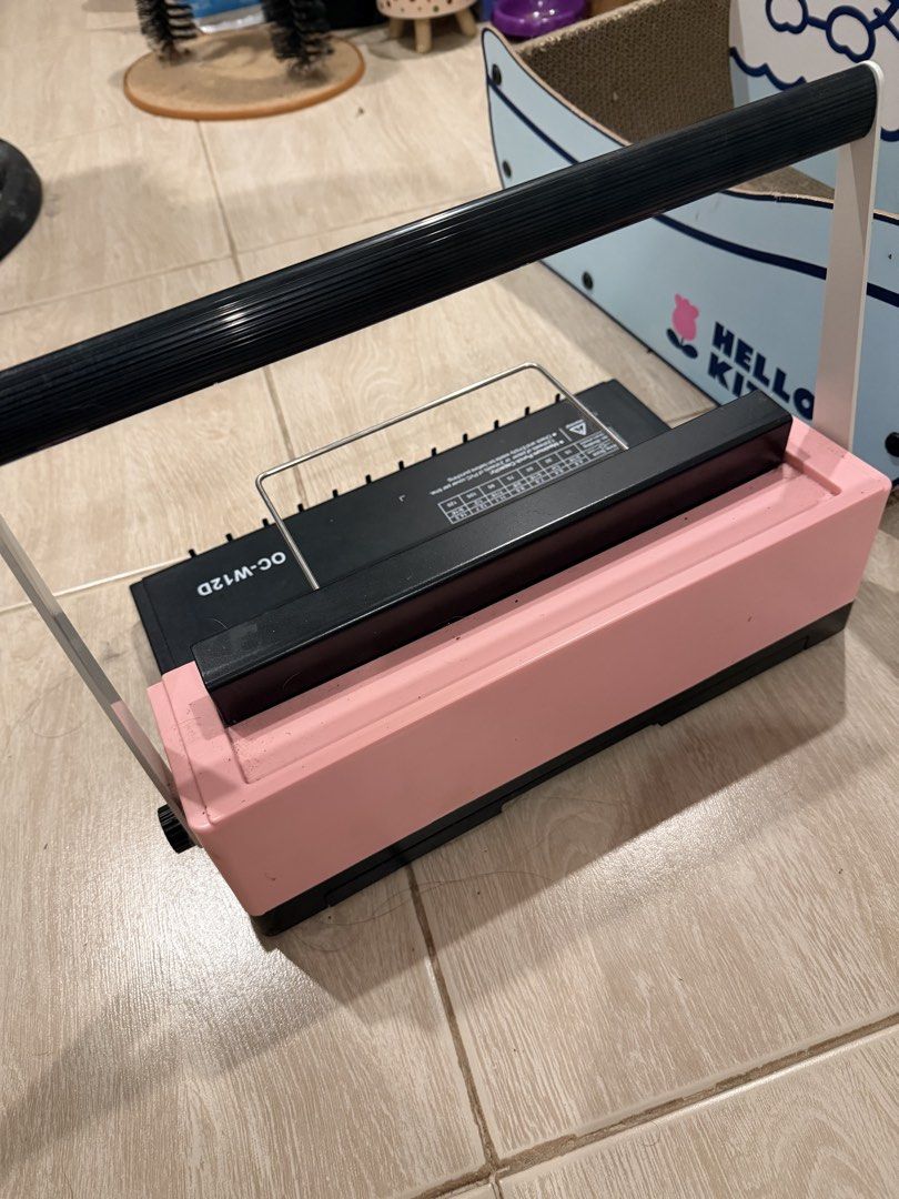 Officom OC-W12D Wire Binding Machine (Category: Office & Business Technology) located in Quezon City. Submitted by leilamiiii (Listing ID 1471209566, Image 2). Description: - Model: Officom OC-W12D (Pink and Black) - Paper Size: Handles up to A4 size - Punching Capacity: Punches up to 12 sheets at once - Features: Built-in wire size guide and clear alignment markings - Build: Sturdy metal handle across the top - Condition: Fully functional, perfe