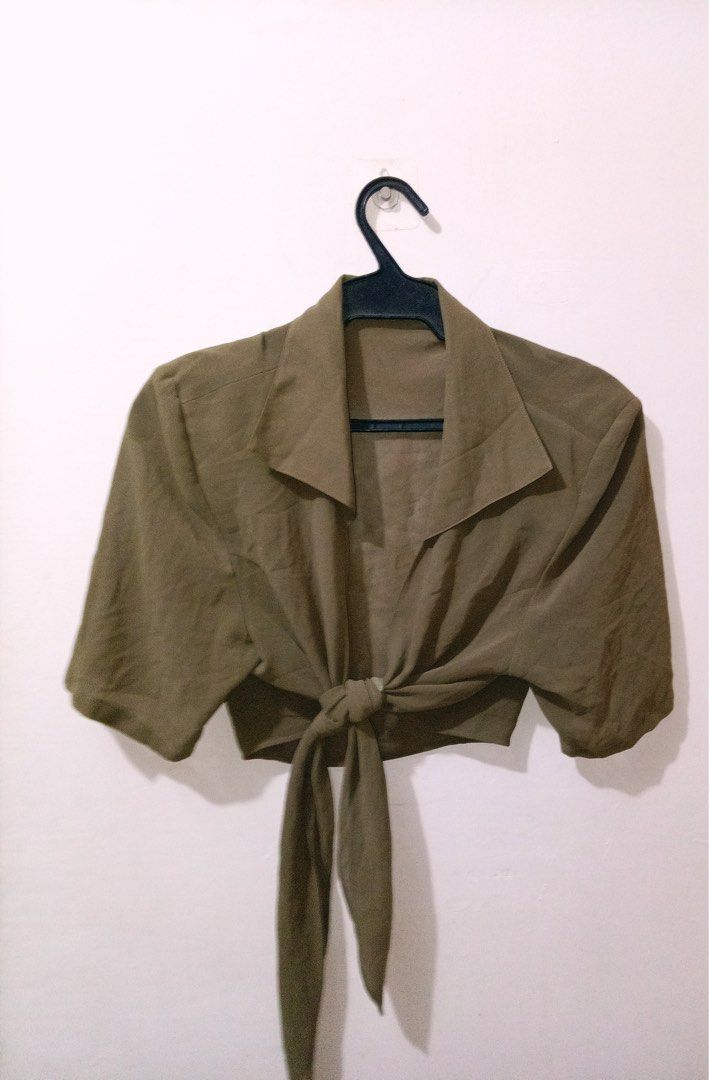 Olive green tie-front crop top small medium (Category: Sleeveless) located in Quezon City. Submitted by charitoo369 (Listing ID 1471294659, Image 3). Description: - Color: Olive green - Style: Crop top with short sleeves and pointed collar - Detail: Front tie closure with long fabric straps - Material: Lightweight and slightly sheer - Fit: Best for small to medium frames - Condition: Clean and ready to wear Na cut tag pero this is imported and br