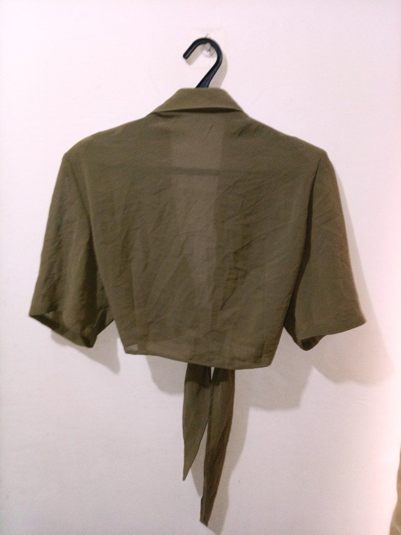 Olive green tie-front crop top small medium (Category: Sleeveless) located in Quezon City. Submitted by charitoo369 (Listing ID 1471294659, Image 2). Description: - Color: Olive green - Style: Crop top with short sleeves and pointed collar - Detail: Front tie closure with long fabric straps - Material: Lightweight and slightly sheer - Fit: Best for small to medium frames - Condition: Clean and ready to wear Na cut tag pero this is imported and br