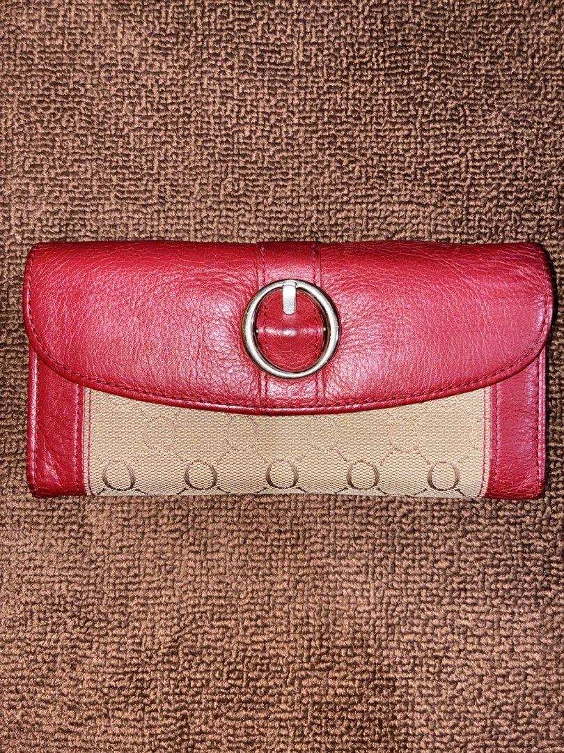 Oroton Red and Beige Monogram Long Wallet (Category: Wallets & Card holders) located in Placer. Submitted by talaalond61563 (Listing ID 1471226746, Image 1). Description: - Brand: Oroton - Material: Red leather and beige monogram fabric - Closure: Flap with silver-tone ring buckle and double snap buttons - Interior Features: Multiple card slots, ID window, and zippered compartment - Lining: Deep red grained leather throughout - Branding: Debossed