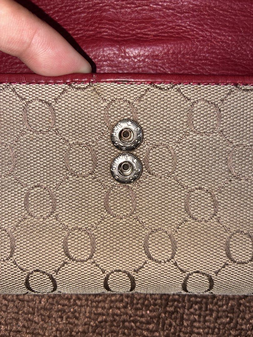 Oroton Red and Beige Monogram Long Wallet (Category: Wallets & Card holders) located in Placer. Submitted by talaalond61563 (Listing ID 1471226746, Image 3). Description: - Brand: Oroton - Material: Red leather and beige monogram fabric - Closure: Flap with silver-tone ring buckle and double snap buttons - Interior Features: Multiple card slots, ID window, and zippered compartment - Lining: Deep red grained leather throughout - Branding: Debossed