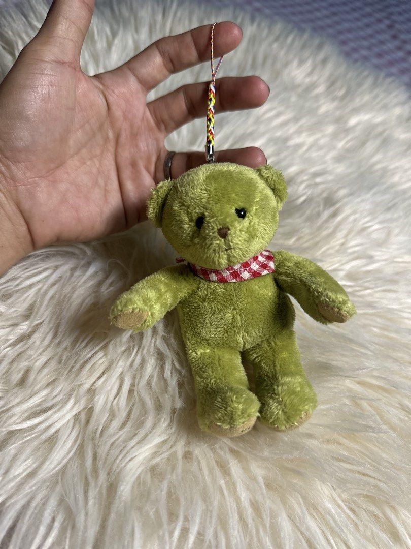 Petit Coup cute green plush teddy bear keychai (Category: Plushies & Soft Toys) located in Davao. Submitted by favoritepreloved (Listing ID 1471268407, Image 2). Description: 💜 wearing a red-and-white gingham checkered scarf and attached to a colorful braided strap..