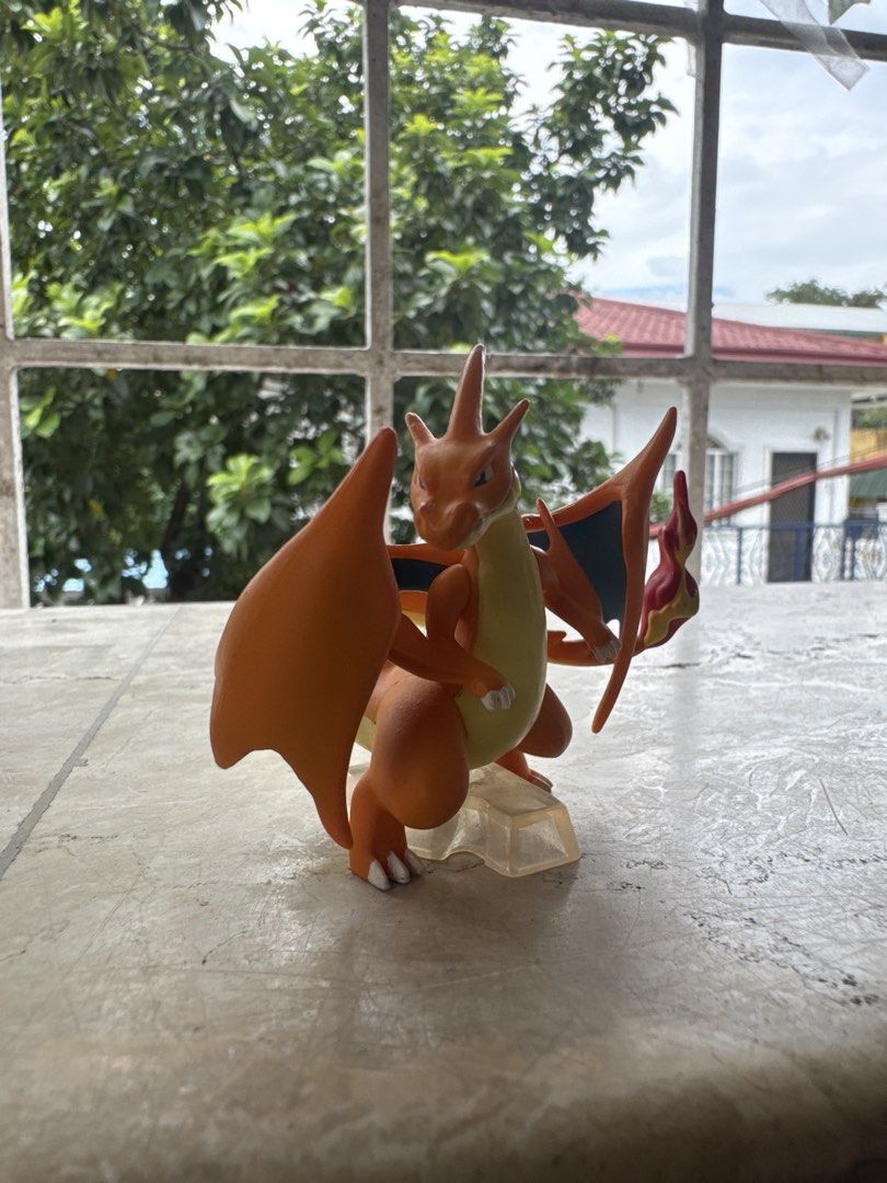 Pokemon Charizard Action Figure with Clear Base (Category: Figurines & Statues) located in Quezon City. Submitted by JDC_Onlineshop (Listing ID 1471145446, Image 2). Description: - Official Pokémon Charizard collectible figure - Vibrant orange body, cream belly, and dark blue wing interiors - Features detailed flame on the tail - Stands securely on a clear acrylic base - Clean piece with solid paint application - Perfect for collector shelves or 