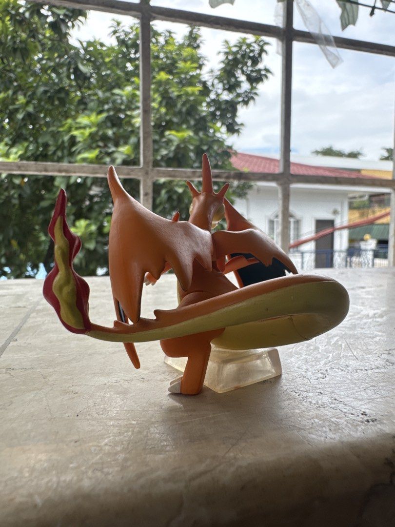 Pokemon Charizard Action Figure with Clear Base (Category: Figurines & Statues) located in Quezon City. Submitted by JDC_Onlineshop (Listing ID 1471145446, Image 3). Description: - Official Pokémon Charizard collectible figure - Vibrant orange body, cream belly, and dark blue wing interiors - Features detailed flame on the tail - Stands securely on a clear acrylic base - Clean piece with solid paint application - Perfect for collector shelves or 