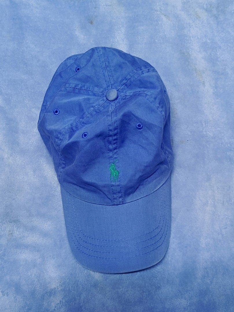 Polo Ralph Lauren Blue Baseball Cap (Category: Caps & Hats) located in City of Isabela. Submitted by warmbird.d06e6f (Listing ID 1471188419, Image 1). Description: - Brand: Polo Ralph Lauren - Color: Classic Blue - Material: 100% Breathable Cotton - Design: Classic six-panel cap with embroidered green pony logo on front - Features: Curved brim, stitched ventilation eyelets - Fit: Fully adjustable strap at the back for a custom fit - Condition: Br