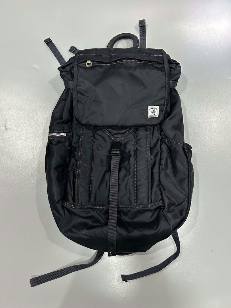 Porter international backpack nylon (Category: Backpacks) located in Muntinlupa City. Submitted by twoangels.11.14.2023 (Listing ID 1471212157, Image 2). Description: The image shows a black nylon Porter International flap-top backpack featuring a top zipper pocket, a central quick-release buckle strap, vertical pleat-style stitching, side/front zip compartments, and the signature Porter patch label..