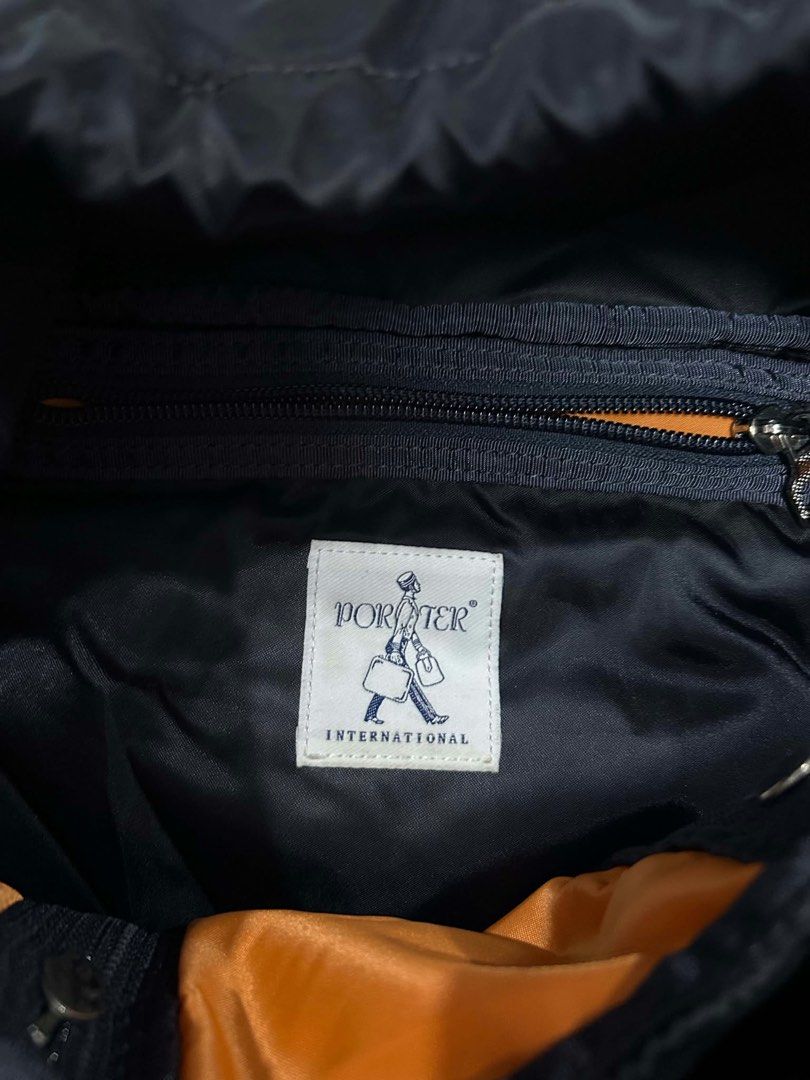 Porter international backpack nylon (Category: Backpacks) located in Muntinlupa City. Submitted by twoangels.11.14.2023 (Listing ID 1471212157, Image 3). Description: The image shows a black nylon Porter International flap-top backpack featuring a top zipper pocket, a central quick-release buckle strap, vertical pleat-style stitching, side/front zip compartments, and the signature Porter patch label..