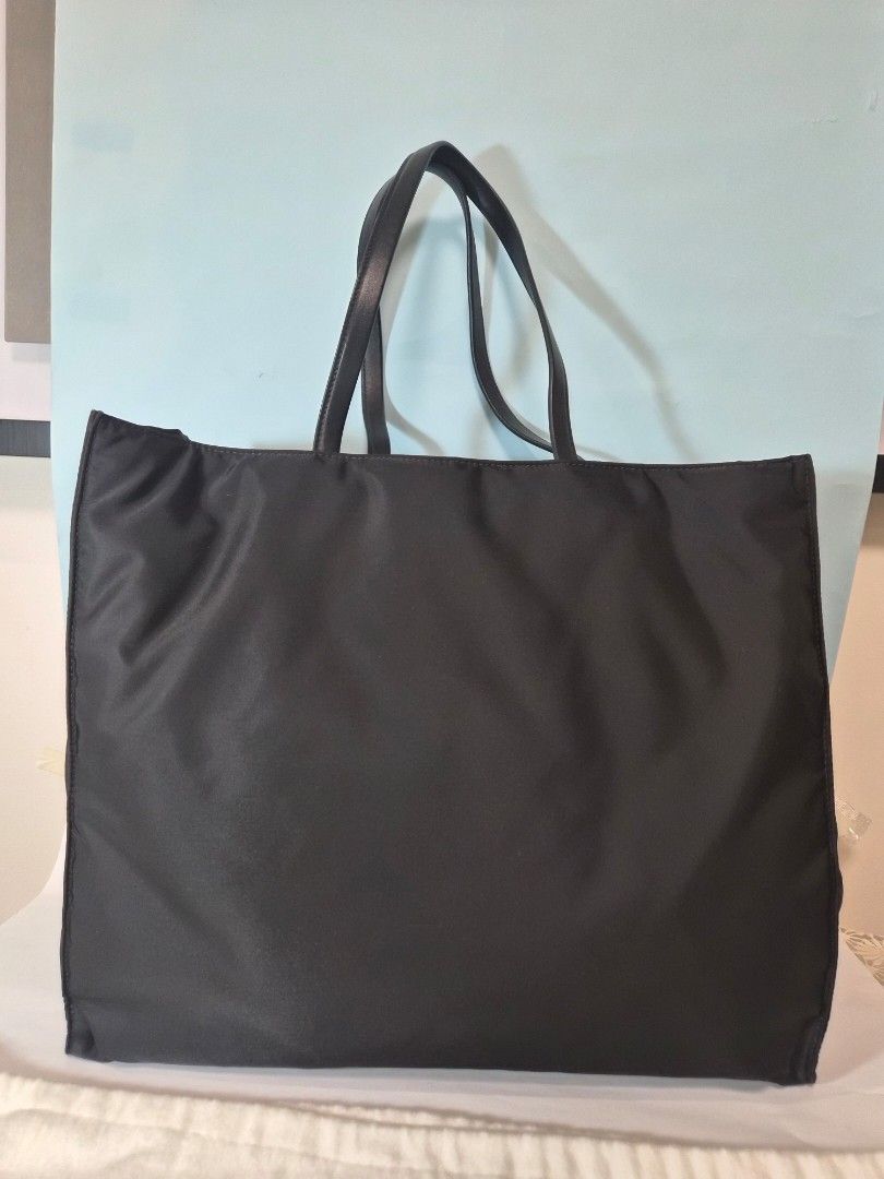 Prada Black Nylon Tote Bag (Category: Luxury Bags & Wallets) located in Manila. Submitted by prelovedbyc.hannah (Listing ID 1471232390, Image 3). Description: - Authentic Prada black nylon tote with authenticity certificate card - Premium leather handles and iconic triangle logo plaque - Exterior and interior zipper compartments with signature jacquard lining - Interior Prada Made in Italy plaque - Includes original box, dust bag, and authenticit