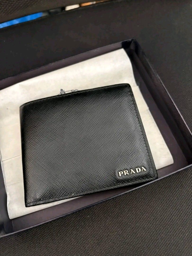 Prada Saffiano Leather Bifold Wallet (Category: Luxury Bags & Wallets) located in Zamboanga. Submitted by thriftbyeems (Listing ID 1471225587, Image 1). Description: FOR SALE! Prada Saffiano Leather Bifold Wallet (featuring the brand's signature metal lettering logo in the corner, resembling model 2MO513) RANK A AUTHENTIC 100% COMPLETE BOX AND CERTIFICATE DM TO PURCHASE 📲.