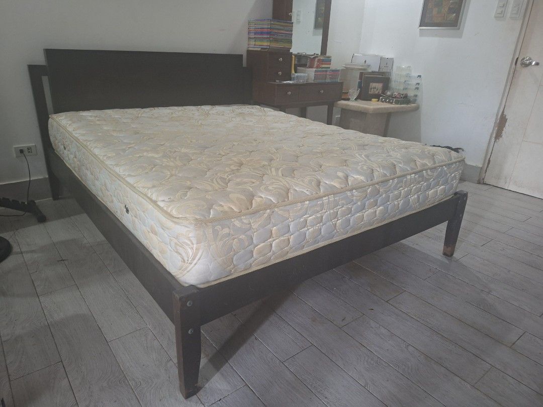 Queen Sized Dark brown wooden bed frame with cream pattern spring mattress (Category: Bed Frames & Mattresses) located in Las Pinas. Submitted by feliboykins (Listing ID 1471216844, Image 2). Description: - Sturdy dark wood bed frame with a matching headboard - Includes a thick, comfortable spring mattress with cream and beige pattern - Standard double or queen size - Solid wooden legs for strong and reliable support - Ideal for master bedrooms o