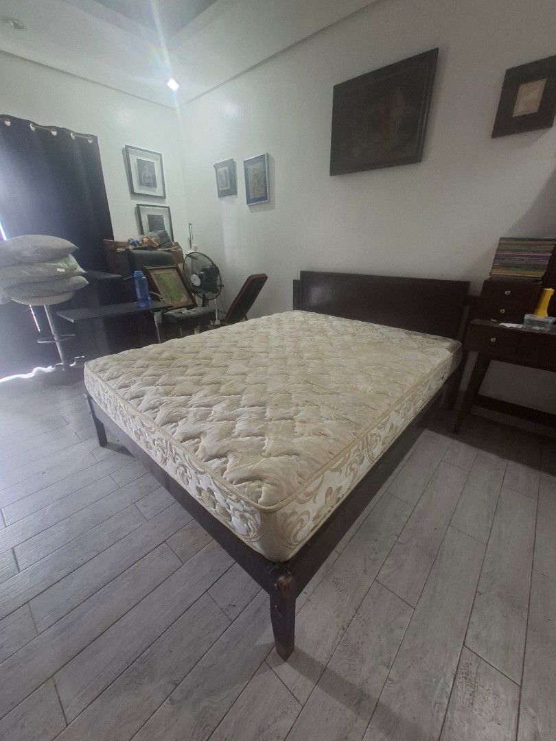 Queen Sized Dark brown wooden bed frame with cream pattern spring mattress (Category: Bed Frames & Mattresses) located in Las Pinas. Submitted by feliboykins (Listing ID 1471216844, Image 1). Description: - Sturdy dark wood bed frame with a matching headboard - Includes a thick, comfortable spring mattress with cream and beige pattern - Standard double or queen size - Solid wooden legs for strong and reliable support - Ideal for master bedrooms o