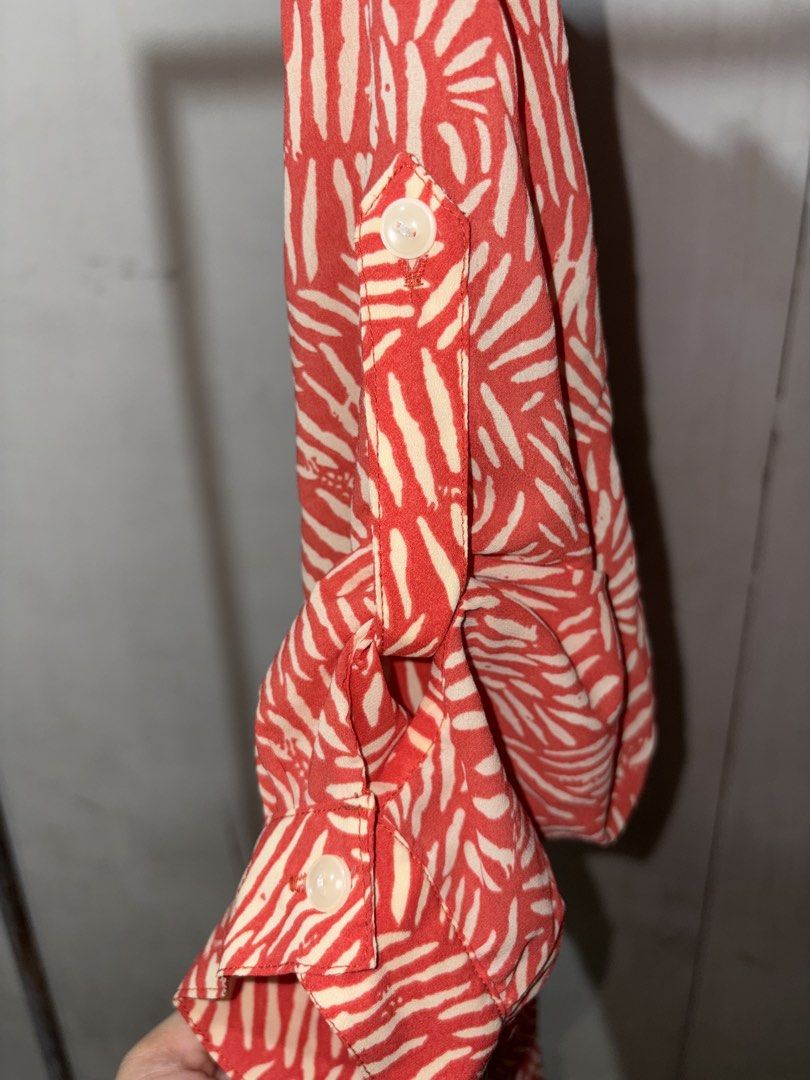 Red and White Abstract Print Button-Down Shirt (Category: Blouses) located in Cavite. Submitted by earthread (Listing ID 1471188211, Image 3). Description: - Red and white abstract all-over print - Collared neckline with front button closure - Versatile roll-up sleeves with tab and button details - Lightweight fabric, ideal for layering or standalone wear.