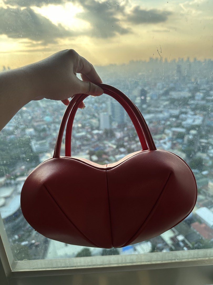 Red Heart Shaped Leather Handbag (Category: Purses & Pouches) located in Imus. Submitted by ann__xoxo (Listing ID 1471165541, Image 3). Description: - Red heart-shaped structured bag - Unique puffed panels with clean stitching - Vibrant red exterior and solid red interior lining - Convenient top handles - Perfect statement piece for dates and nights out - Grab it before it goes!.