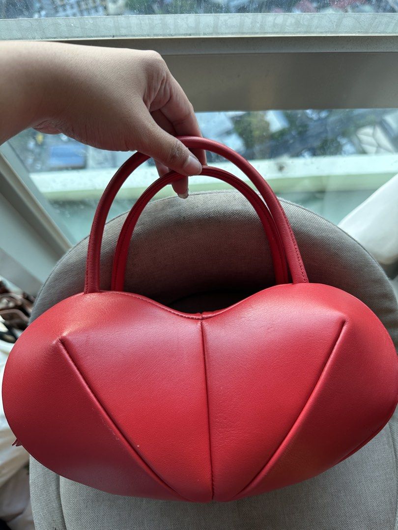 Red Heart Shaped Leather Handbag (Category: Purses & Pouches) located in Imus. Submitted by ann__xoxo (Listing ID 1471165541, Image 2). Description: - Red heart-shaped structured bag - Unique puffed panels with clean stitching - Vibrant red exterior and solid red interior lining - Convenient top handles - Perfect statement piece for dates and nights out - Grab it before it goes!.