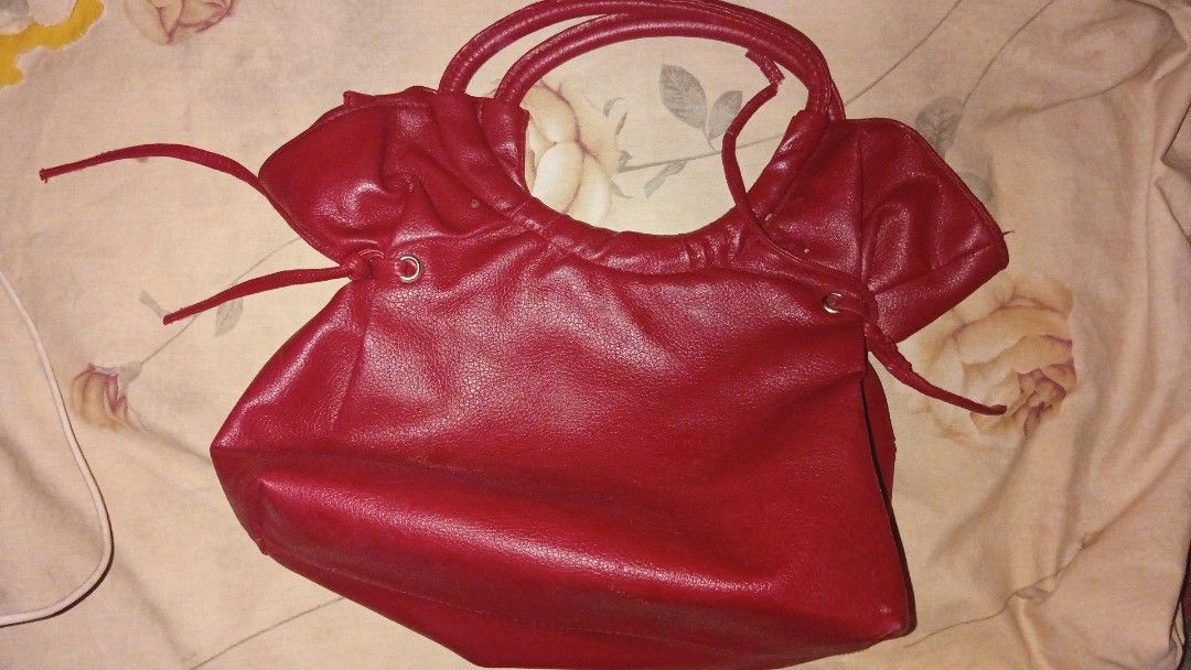 Red Leather Shoulder Bag with Gold Hardware (Category: Luxury Bags & Wallets) located in Iligan City. Submitted by freiko (Listing ID 1471275538, Image 2). Description: - Color: Bright red - Material: Soft faux leather with gold-tone hardware - Straps: Double top handles - Details: Chic side drawstring accents - Interior: Spacious beige patterned fabric lining - Closure: Secure top zipper closure - Condition: Brand new/Excellent.