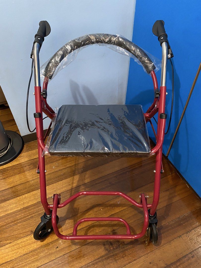 Red Rollator Walker with Seat and Wheels (Category: Wheelchairs) located in Quezon City. Submitted by llreiss (Listing ID 1471218671, Image 1). Description: Red mobility walker with four wheels, hand brakes, and a padded seat. Protective plastic wrap still covers the seat, backrest, and left front wheel. Adjustable height handles with hand grips. Sturdy frame folds up easily for transport or storage. Great mobility aid for seniors or recovery. Ne