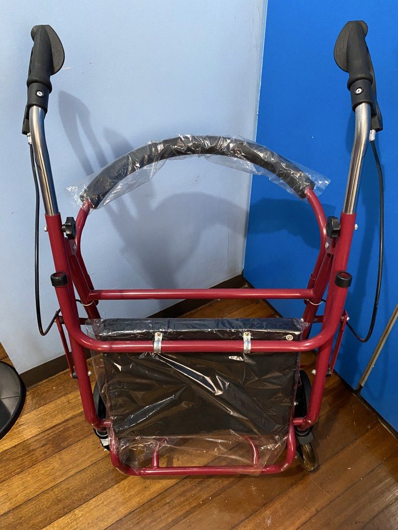 Red Rollator Walker with Seat and Wheels (Category: Wheelchairs) located in Quezon City. Submitted by llreiss (Listing ID 1471218671, Image 2). Description: Red mobility walker with four wheels, hand brakes, and a padded seat. Protective plastic wrap still covers the seat, backrest, and left front wheel. Adjustable height handles with hand grips. Sturdy frame folds up easily for transport or storage. Great mobility aid for seniors or recovery. Ne