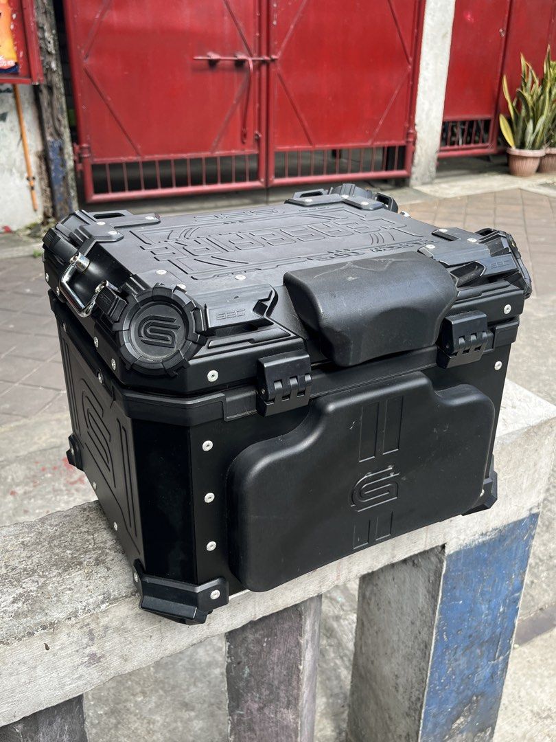 SEC Motorcycle Top Box Black Aluminum Storage (Category: Body Parts and Accessories) located in Manila. Submitted by yurimahboy (Listing ID 1471171945, Image 3). Description: - Brand: SEC Motorcycle Top Box - Color: Matte Black with reflective yellow side branding - Material: Sturdy, durable aluminum build - Security: Dual locking latches - Interior: Leatherette lining with SEC debossed pattern, lid organizer pockets, and cross straps - Extra: In