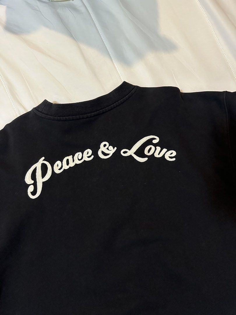 Second Love Peace & Love Sweatshirt (Category: Longsleeves) located in Bulacan. Submitted by juyeonloey (Listing ID 1471262916, Image 2). Description: - Brand: 2nd Closet Atelier - Color: Black - Size: M (tag on collar) - Front details: Embroidered 'SECOND LOVE' text with red heart and smiley face - Back details: White cursive 'Peace & Love' lettering - Pit to pit: ~24.5 inches - Length: ~28.5 inches - Features ribbed cuffs and hem, clean piece w