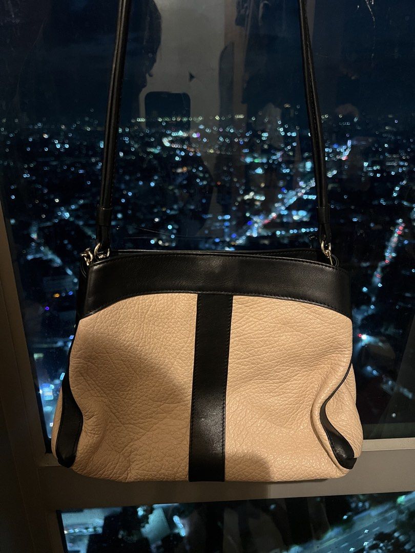 See by Chloe Two-Tone Shoulder Bag (Category: Luxury Bags & Wallets) located in Imus. Submitted by ann__xoxo (Listing ID 1471164144, Image 1). Description: - Brand: See by Chloé - Material: Cream and black leather with clean interior lining - Design: Classic color block with a vertical black stripe and gold chain front accent - Closure: Secure top zip closure - Straps: Comfortable twin shoulder straps - Condition: Very minor signs of wear, excell
