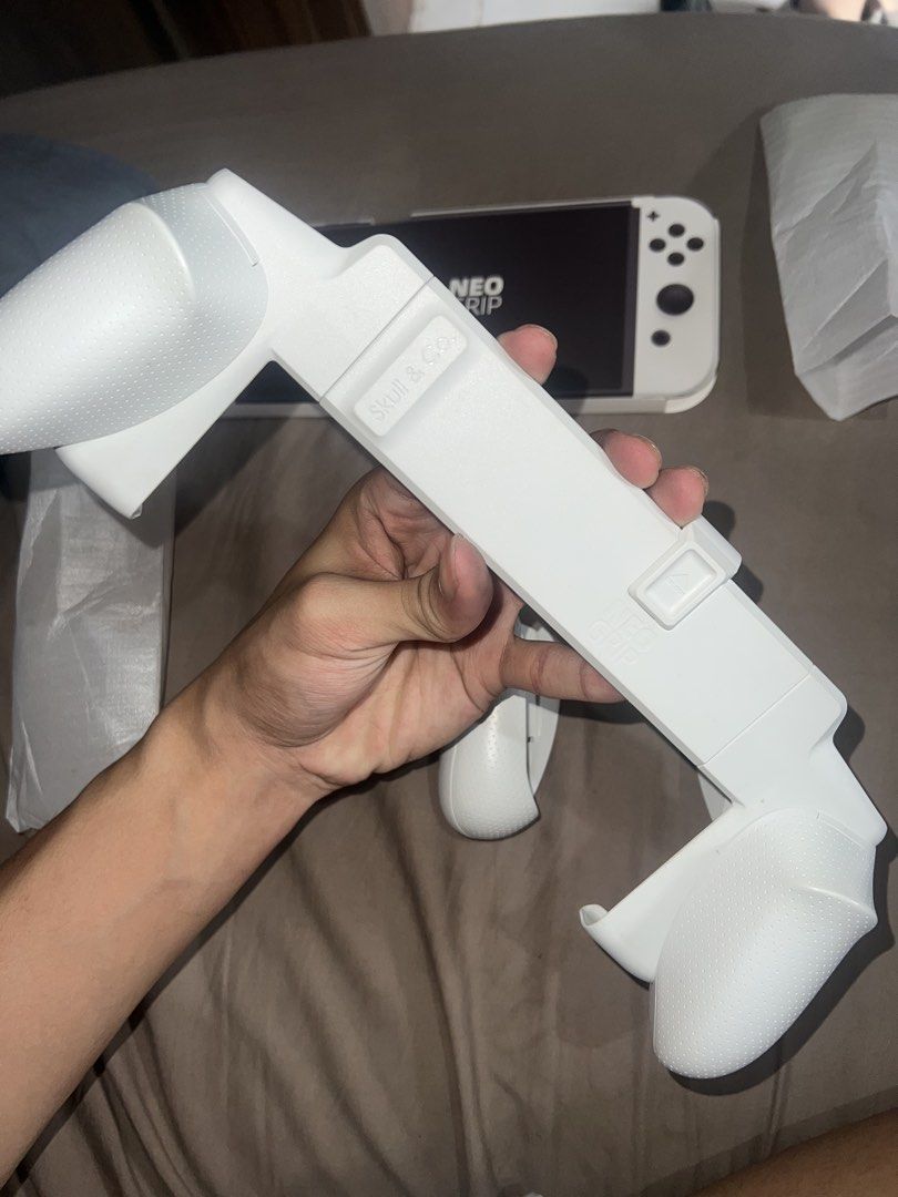 Skull & Co. NeoGrip White for Nintendo Switch (Category: Controllers) located in Manila. Submitted by chris_declutsss (Listing ID 1471184823, Image 2). Description: - Item: Skull & Co. NeoGrip (White) - Compatibility: Fits Nintendo Switch OLED and standard models - Condition: Clean, hardly used, and fits snugly - Includes: Main grip frame, PlusGrip set, and standard grip set - Feature: Ergonomic design for maximum handheld gaming comfort box has 