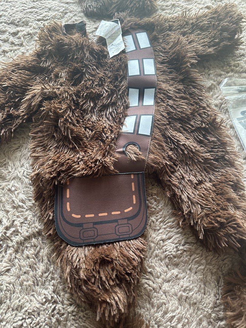 Star Wars Chewbacca Infant Costume (Category: Babies & Kids Fashion) located in Mandaluyong City. Submitted by kacbriz (Listing ID 1471171035, Image 2). Description: Star Wars Chewbacca costume for infants, size 6 to 12 months. Includes fuzzy brown jumpsuit, attached sash, bag detail, and separate headpiece with fluffy fur. Original packaging bag included. Soft material, warm style for babies. Halloween costume.