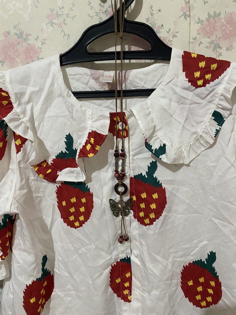Strawberry Print Ruffle Collar Long Sleeve Blouse (Category: Blouses) located in Makati City. Submitted by oncejjang (Listing ID 1471125575, Image 2). Description: - Design: White button-down blouse featuring an adorable red strawberry print with green leaves and yellow seeds - Collar: Statement big ruffled sailor collar for a cute vintage aesthetic - Sleeves: Long sleeves finished with comfortable ruffled elastic cuffs - Fabric: Lightweight, bre
