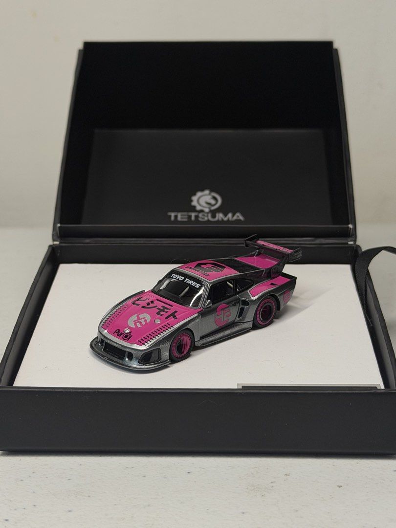 Tetsuma Bisimoto 1:64 Diecast (Category: Vehicle & Diecast Models) located in Manila. Submitted by kelvs1435 (Listing ID 1471187780, Image 2). Description: Tetsuma Bisimoto Make: Bisimoto Model: 935 K3 (EVMOTO) Scale: 1:64 Size: 7.5 cm long, 3.25 cm wide, 1.5 cm high Exterior Color: Metallic Grey with Pink Livery Interior Color: Black Seats, White Roll Cage, Purple Accents Cast Material: Resin and Hand-Made Production Run: Limited Edition 1000 Pi