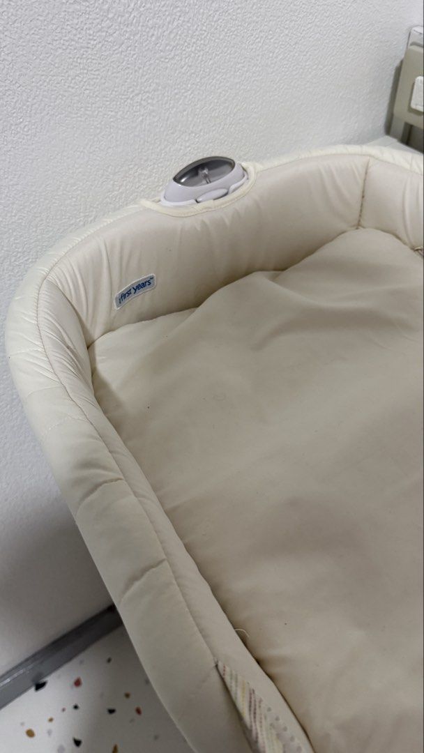 The First Years Portable Infant Sleeper (Category: Cots & Cribs) located in Santa Cruz. Submitted by jlchua (Listing ID 1471249341, Image 3). Description: - Brand: The First Years - Color: Quilted off-white - Design: Folds down easily into a compact carry bag with handles for travel - Comfort & Safety: Breathable mesh sides to keep baby cool and secure padded sides - Extra Feature: Built-in nightlight unit located at the head - Convenience: Pops 