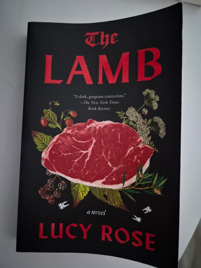 The Lamb by Lucy Rose (Category: Storybooks) located in Las Pinas. Submitted by storage485 (Listing ID 1471171314, Image 1). Description: - Title: The Lamb by Lucy Rose - Format: Hardcover, clean copy with crisp pages - Genre: Dark literary fiction - Cover Art: Striking illustration featuring raw steak, botanical elements, berries, and tiny teeth - Accolades: Includes a quote from The New York Times Book Review on the front cover - Condition: Exc