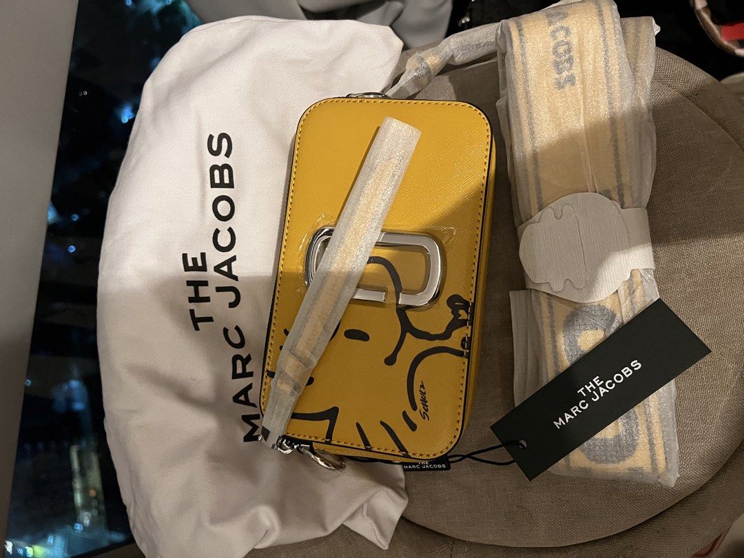The Marc Jacobs Snoopy Snapshot Camera Bag Yellow (Category: Other Accessories) located in Imus. Submitted by ann__xoxo (Listing ID 1471178684, Image 3). Description: - Brand new with tags and protective plastic intact - Authentic Marc Jacobs Snapshot Camera Bag - Limited Snoopy edition in Chrysanth Emum Multi (Yellow) - Style number: M0016815-735 - Features double zip compartments and chic silver hardware - Comes with the original matching patte