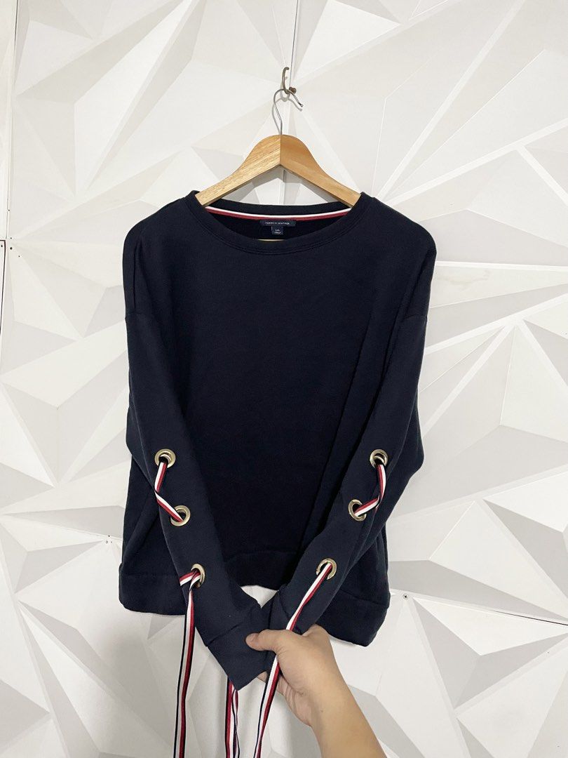 Tommy Hilfiger Laced Sleeve Sweatshirt (Category: Coats, Jackets and Outerwear) located in Cabuyao City. Submitted by ParadisethriftedPh (Listing ID 1471119925, Image 3). Description: Cr: 9.2/10 Dimensions W: 23.5 L: 23.5 - Brand: Tommy Hilfiger - Color: Navy Blue - Size: Large - Condition: Brand new with tags - Fit: Relaxed fit with drop shoulders - Details: Classic crewneck, red and white inner collar branding tape, and unique side grommets lac