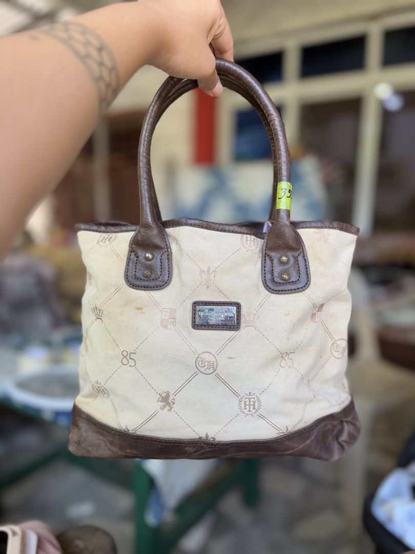 Tommy Hilfiger Monogram hand Bag Brown Cream (Category: Tote Bags) located in Manila. Submitted by dorilorenr48954 (Listing ID 1471227003, Image 1). Description: - Brand: Tommy Hilfiger - Style: Monogram Tote (Cream canvas with brown faux leather trim) - Features: Dual top handles, silver logo plaque on the front - Interior: Blue fabric lining with a signature red Tommy Hilfiger brand patch - Condition: Pre-owned with light stains on the exterior