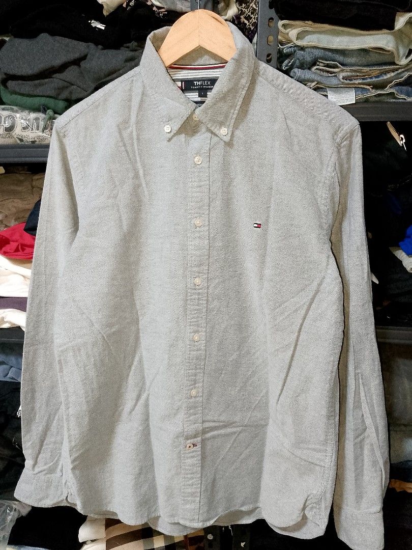 Tommy Hilfiger TH Flex Grey Button-Down Shirt Size S (Category: Tshirts & Polo Shirts ) located in Manila. Submitted by mjthrifted_second (Listing ID 1471196556, Image 1). Description: - Brand: Tommy Hilfiger (TH Flex Collection) - Color: Grey - Size: S (170/100B) / Regular Fit -Dimes: 20/27 - Material: 97% Cotton, 3% Elastane (Slight stretch for comfort) - Details: Classic button-down collar with embroidered flag logo on chest - Condition: Clean