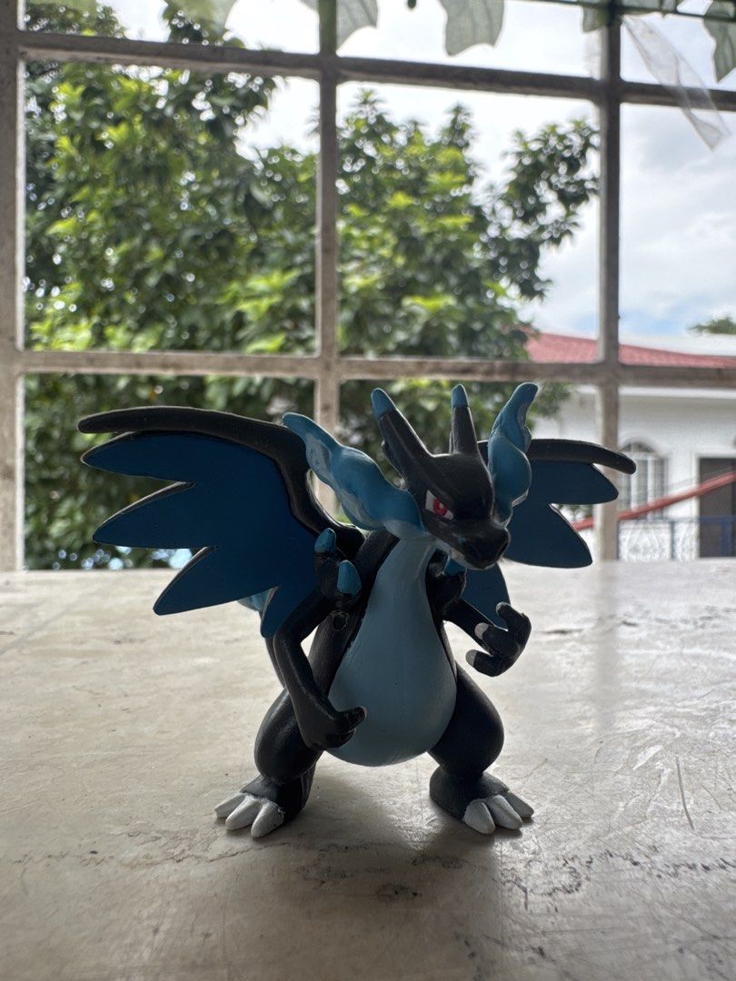 TOMY Pokémon Mega Charizard X Figure Nintendo (Category: Figurines & Statues) located in Quezon City. Submitted by JDC_Onlineshop (Listing ID 1471144681, Image 2). Description: - Authentic TOMY Mega Charizard X collectible figurine - Official Nintendo and Pokémon stamps on the back of the wing - Features the classic black and blue design with red eyes and blue flame tail - Stands on its own securely - Great addition to your Pokémon collection.
