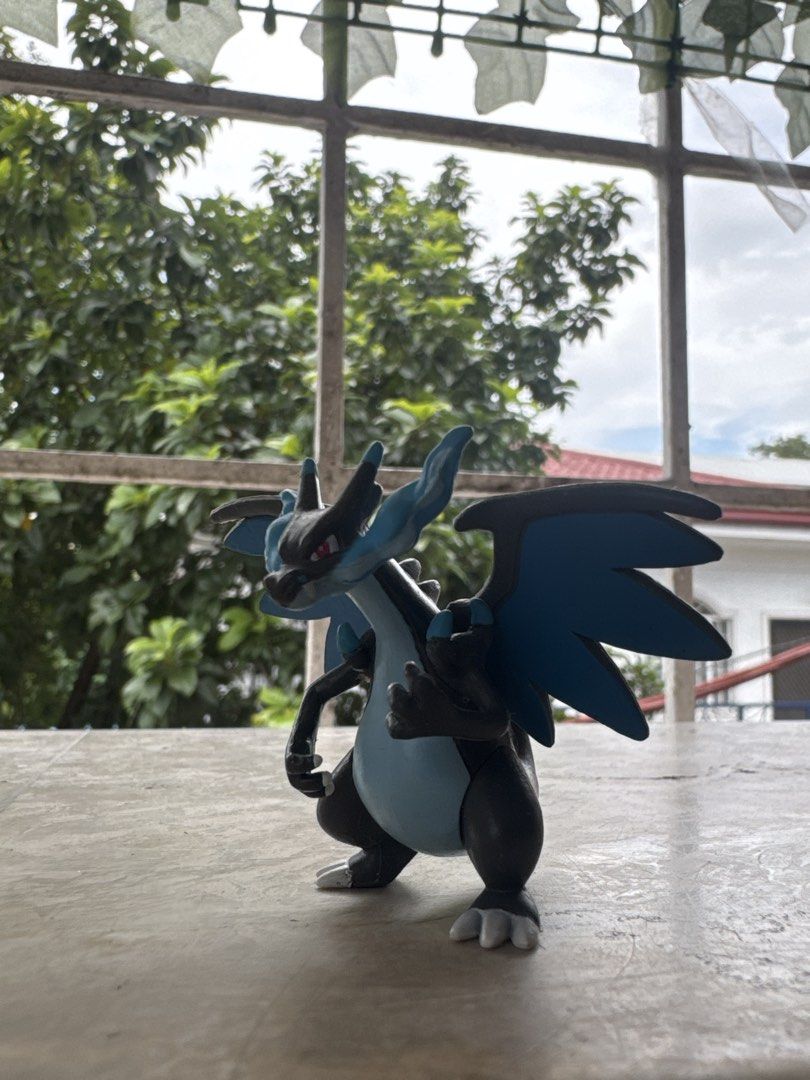 TOMY Pokémon Mega Charizard X Figure Nintendo (Category: Figurines & Statues) located in Quezon City. Submitted by JDC_Onlineshop (Listing ID 1471144681, Image 1). Description: - Authentic TOMY Mega Charizard X collectible figurine - Official Nintendo and Pokémon stamps on the back of the wing - Features the classic black and blue design with red eyes and blue flame tail - Stands on its own securely - Great addition to your Pokémon collection.